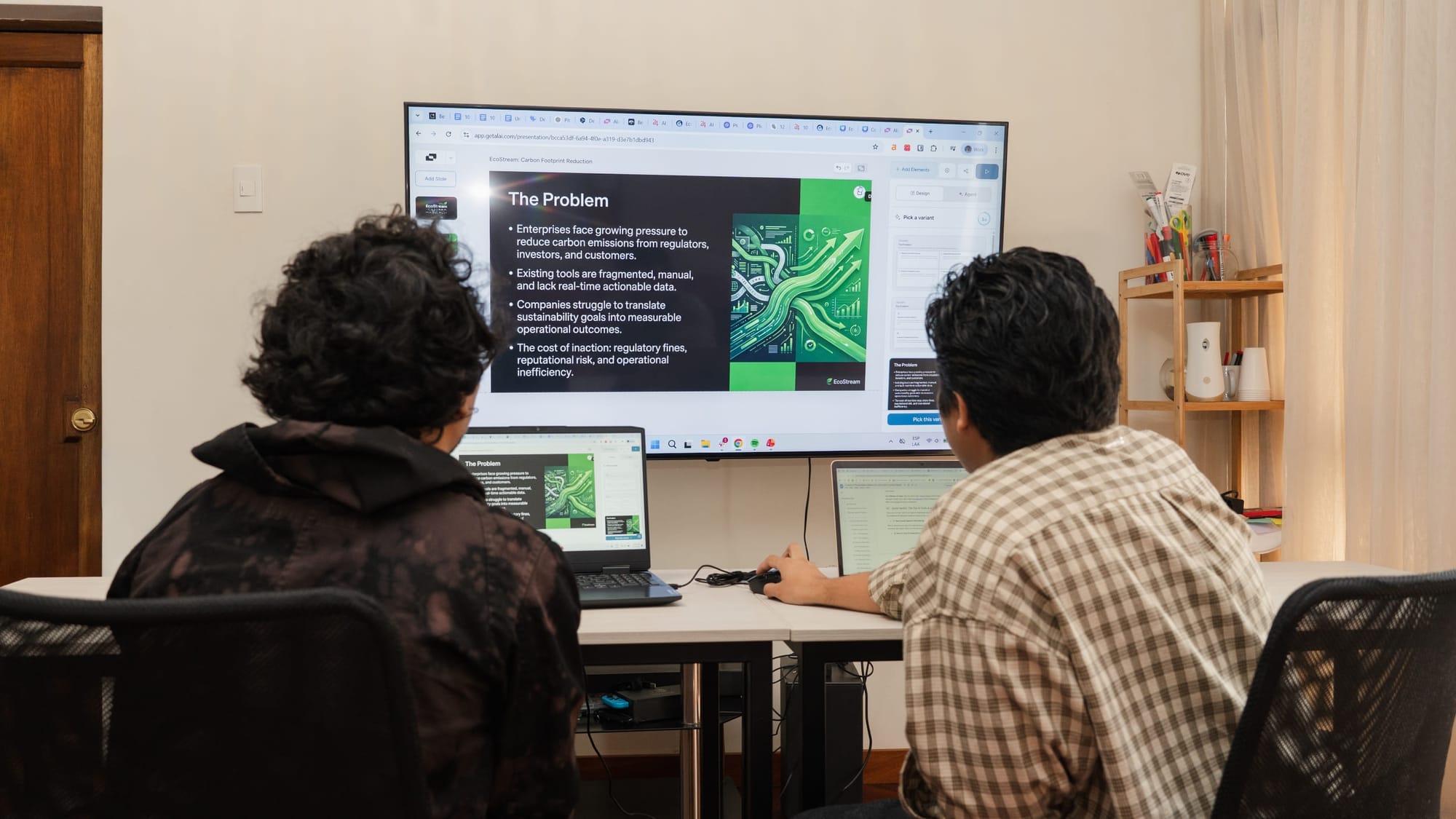 Two 24Slides marketing designers, Gabo and Leo, collaborating in front of a large monitor, testing an AI presentation maker using the green and dark grey EcoStream benchmark prompt.