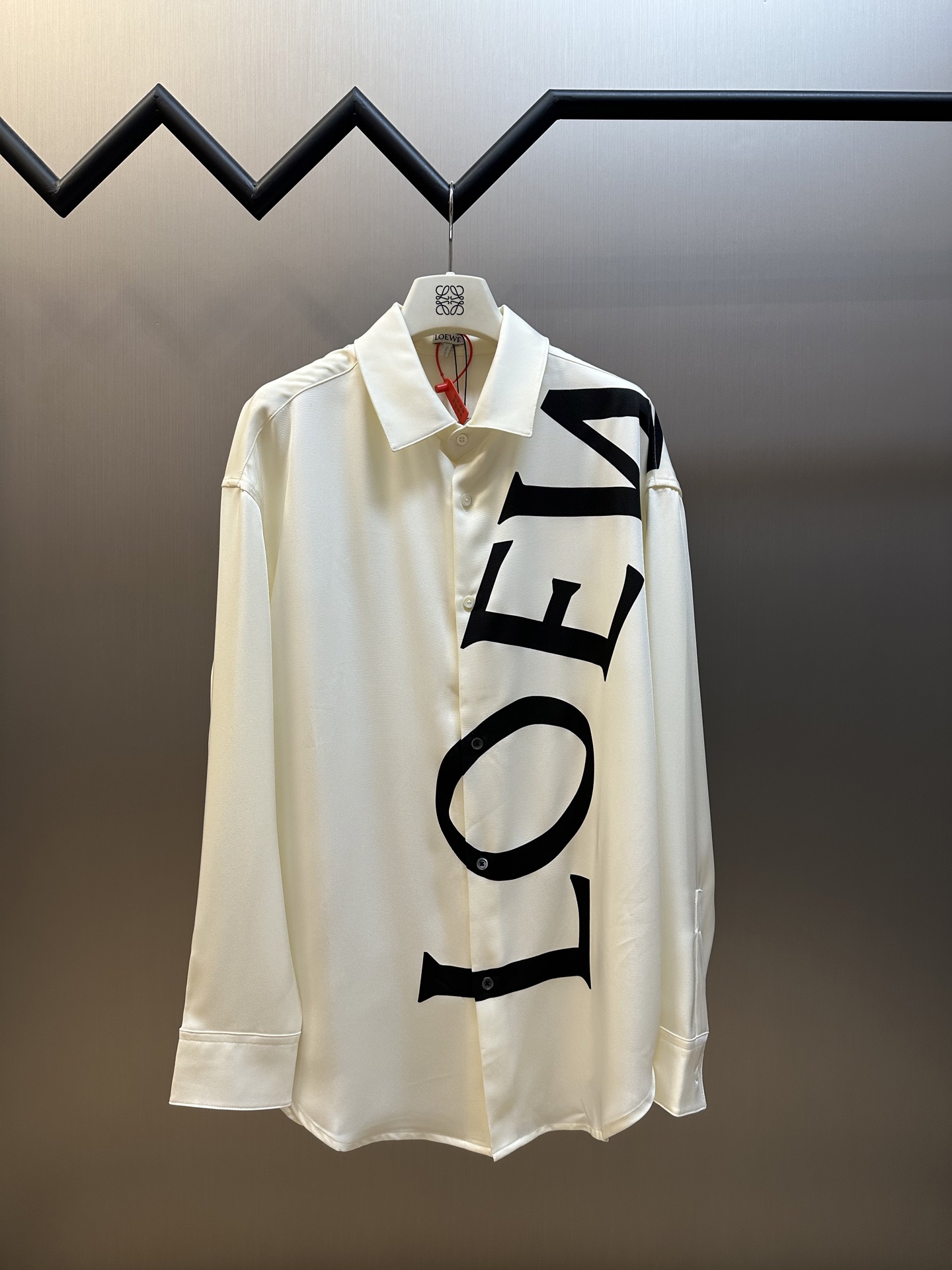 Lew printed silk shirt The custom-made mulberry silk material has a natural luster, with ivory white as the background color, and the black Lew letters printed diagonally on it with ink shadow give a new visual focus in a very tense posture, using a dynamic and irregular beauty to declare the nobility of the brand.
