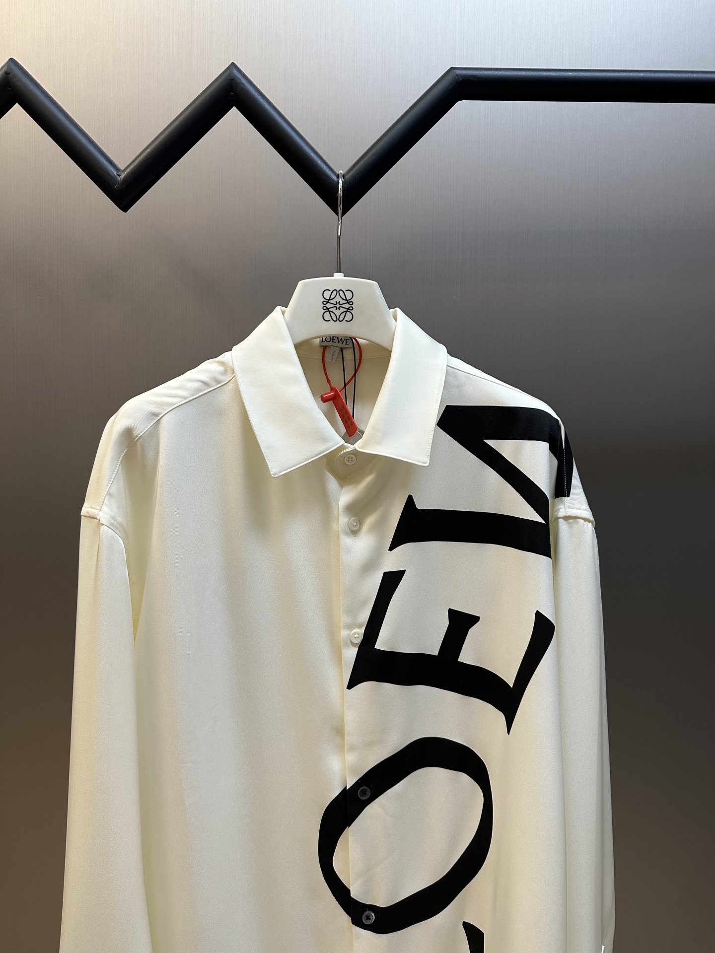 Lew printed silk shirt The custom-made mulberry silk material has a natural luster, with ivory white as the background color, and the black Lew letters printed diagonally on it with ink shadow give a new visual focus in a very tense posture, using a dynamic and irregular beauty to declare the nobility of the brand. - Image 2