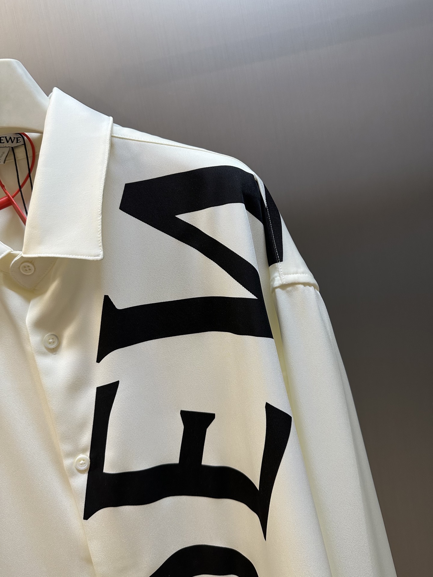 Lew printed silk shirt The custom-made mulberry silk material has a natural luster, with ivory white as the background color, and the black Lew letters printed diagonally on it with ink shadow give a new visual focus in a very tense posture, using a dynamic and irregular beauty to declare the nobility of the brand. - Image 3