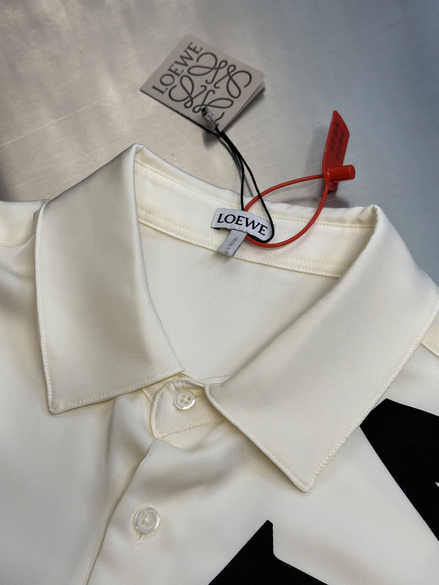 Lew printed silk shirt The custom-made mulberry silk material has a natural luster, with ivory white as the background color, and the black Lew letters printed diagonally on it with ink shadow give a new visual focus in a very tense posture, using a dynamic and irregular beauty to declare the nobility of the brand. - Image 5