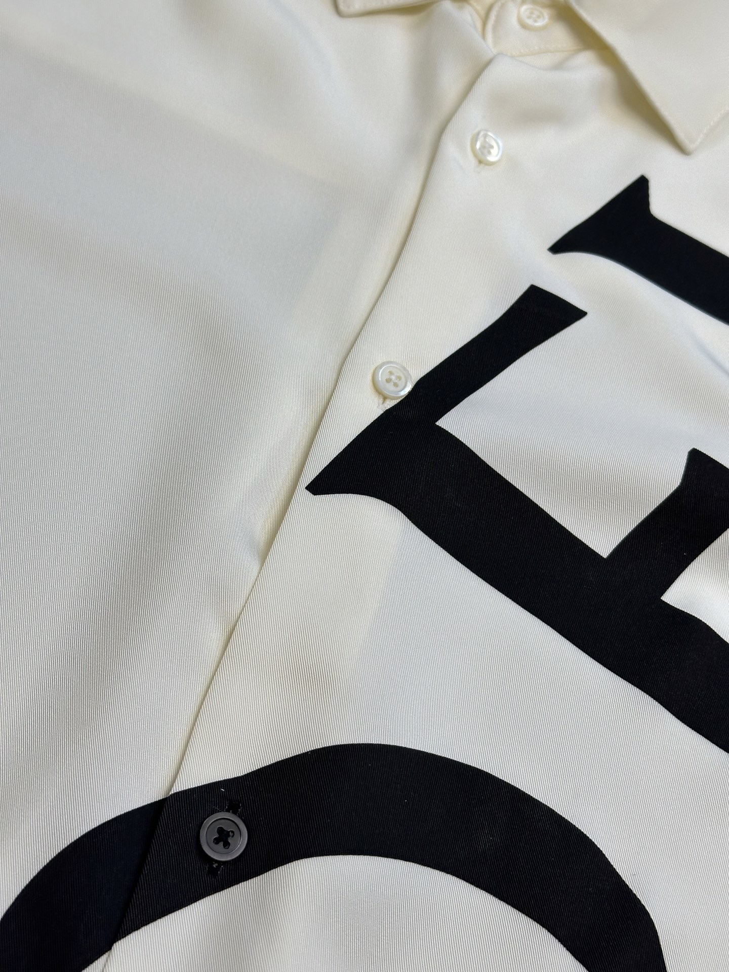 Lew printed silk shirt The custom-made mulberry silk material has a natural luster, with ivory white as the background color, and the black Lew letters printed diagonally on it with ink shadow give a new visual focus in a very tense posture, using a dynamic and irregular beauty to declare the nobility of the brand. - Image 6