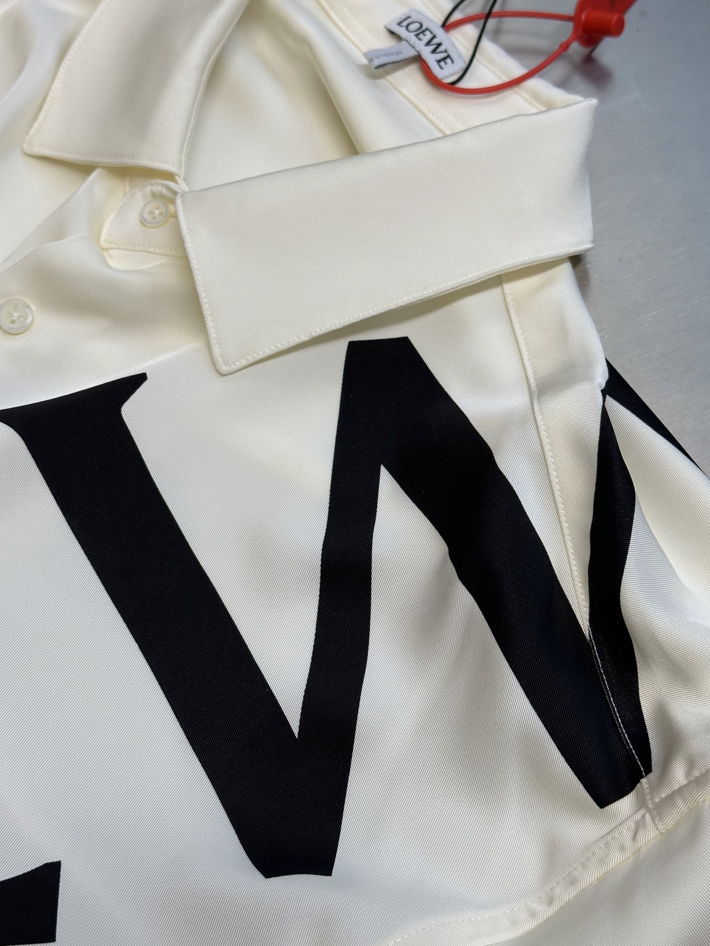 Lew printed silk shirt The custom-made mulberry silk material has a natural luster, with ivory white as the background color, and the black Lew letters printed diagonally on it with ink shadow give a new visual focus in a very tense posture, using a dynamic and irregular beauty to declare the nobility of the brand. - Image 9