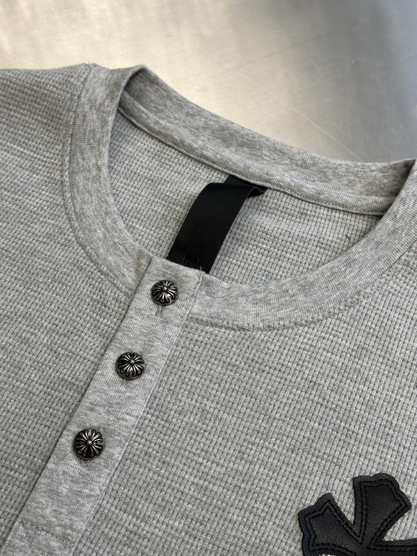 Chrome Hearts Chrome Hearts Cross Silver Button Long Sleeve Customized pure cotton waffle fabric, decorated with a Croix heart cross leather on the chest, the tough edges of the leather pierce the softness of the gray. The hand-stitched logo buckle is like a miniature work of art, and the logo plate on the back sways slightly with the swing of the body, adding a sense of movement and vitality. - Image 5