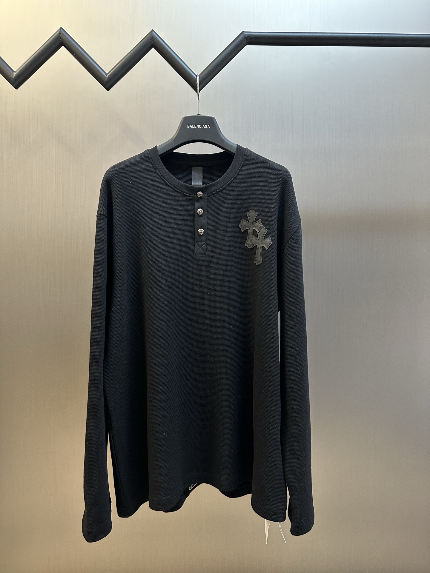 Chrome Hearts Chrome Hearts Cross Silver Button Long Sleeve Customized pure cotton waffle fabric, decorated with a Croix heart cross leather on the chest, the tough edges of the leather pierce the softness of the gray. The hand-stitched logo buckle is like a miniature work of art, and the logo plate on the back sways slightly with the swing of the body, adding a sense of movement and vitality.