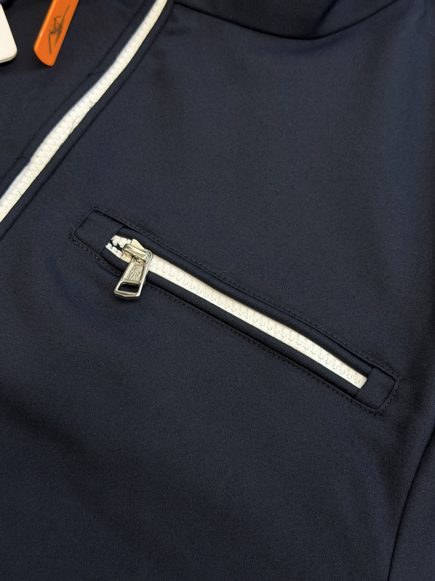 Moc logo pocket zip jacket Customized Mo Chen Yujing cotton brocade blend, three-dimensional stand-up collar creates a smart aura, the main zipper and chest pocket zipper use contrasting teeth, showing exquisite craftsmanship in details. Double green webbing runs vertically through the side of the body, injecting retro sports lines, round logos on the sleeves and arms are implicitly embellished, and elastic cuffs stabilize the version. It combines urban functionality and retro sports aesthetics, interpreting Italian quiet luxury style. - Image 6