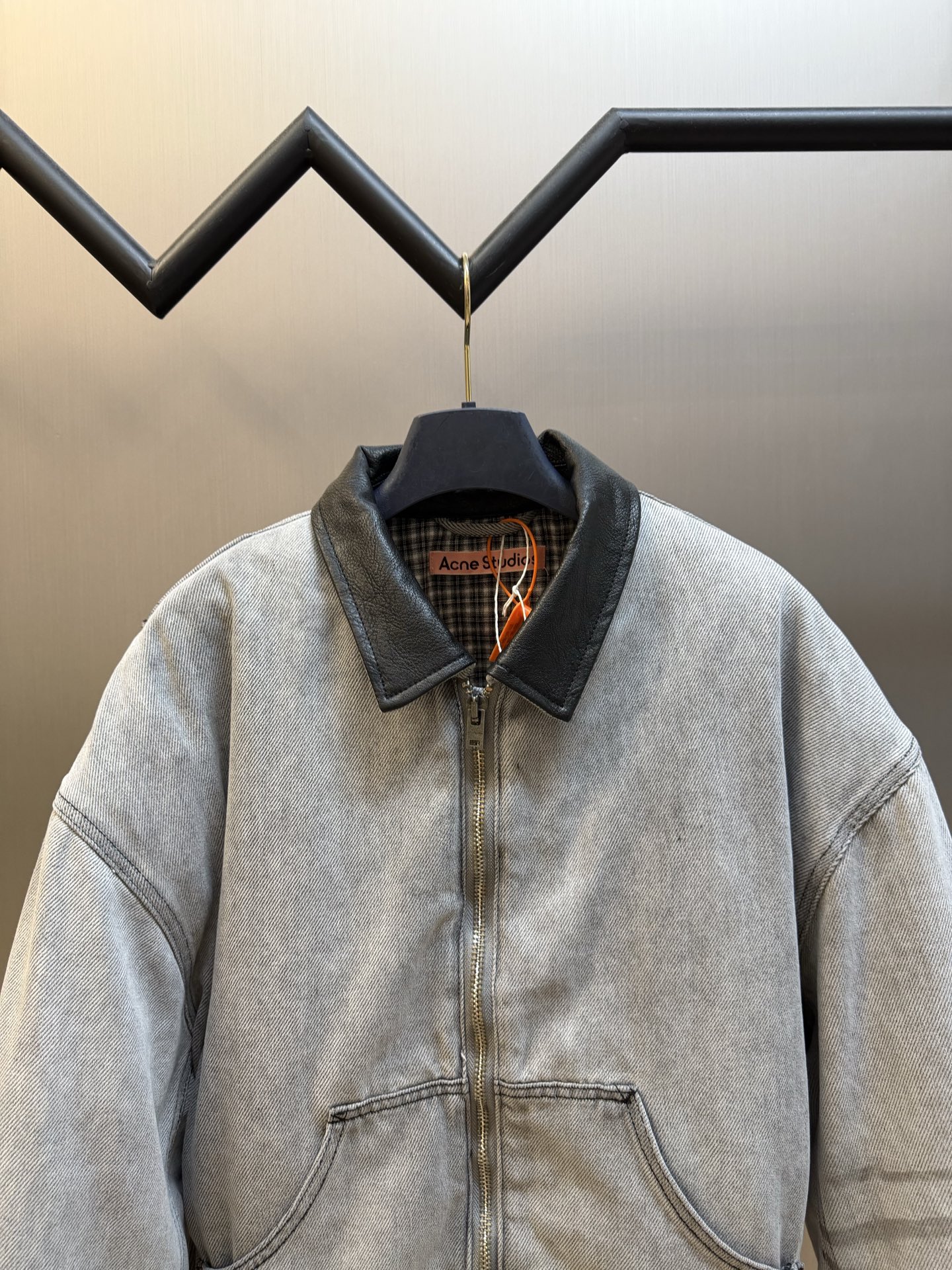 Ac Studios distressed leather cotton denim jacket The outer layer is custom-made weft-ordered organic denim, and the inner layer is custom-made domain-ordered plaid cotton. The entire body is covered in a matte gray tone. The original faded texture is naturally generated. The black leather collar is neatly cut and spliced. The roughness of the denim blends with the smoothness of the leather, creating a collision of rich layers of materials. The arms are embossed with dark patterns, and the patterns are dimly visible. The classic leather label on the back of the neck is properly seated, and the brand's collection imprint is hidden on the back. - Image 2