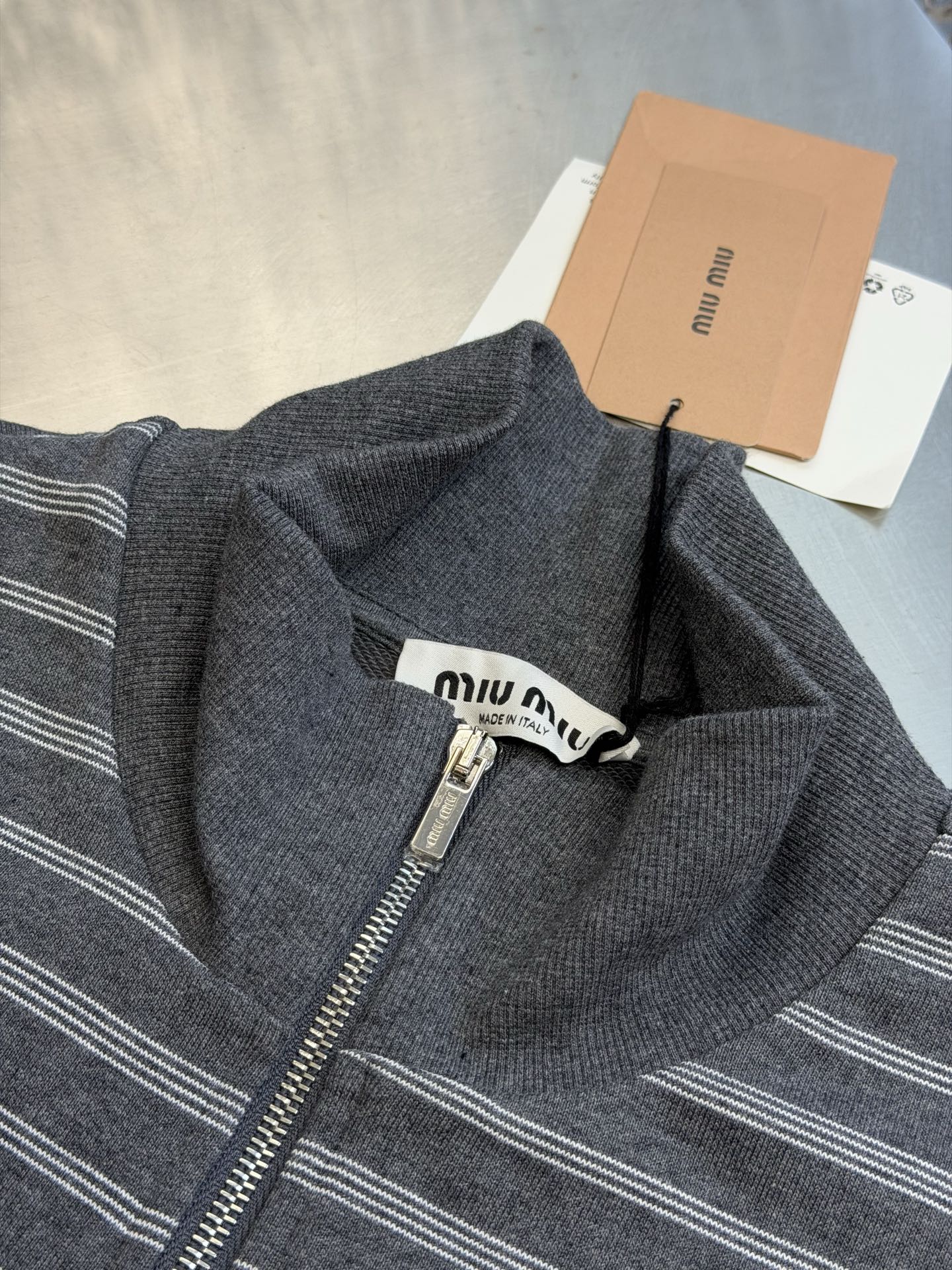 Miu gray and white striped stand collar zipper jacket White and gray interwoven jacquard terry bottom fabric, the main body is made of 24-count double yarn as the top layer, and the bottom layer is 10-count roving terry, with a weight of 380g/m²; the rib part uses a 21-count 2×2 structure, with a weight of 380g/m² - Image 6