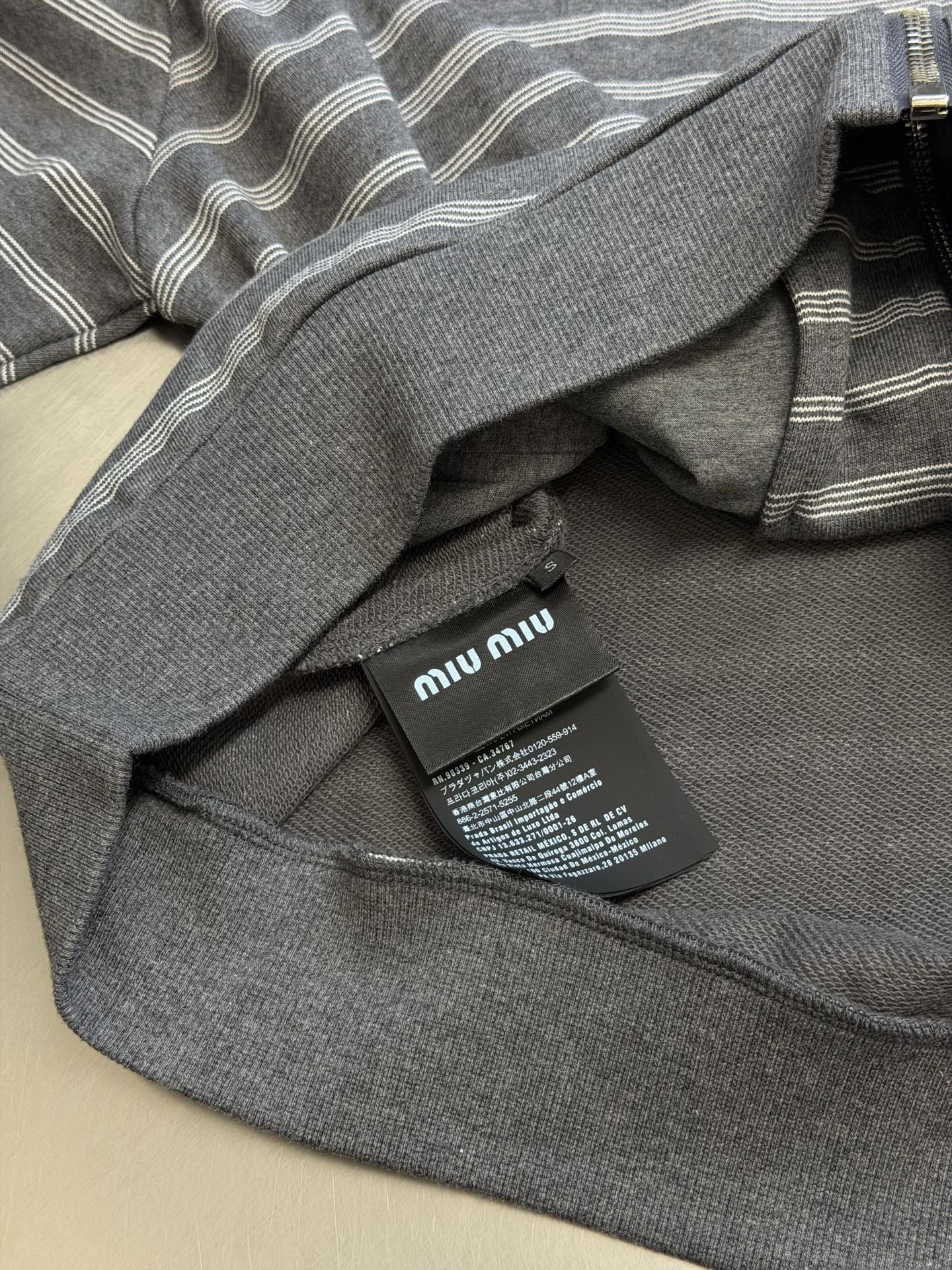 Miu gray and white striped stand collar zipper jacket White and gray interwoven jacquard terry bottom fabric, the main body is made of 24-count double yarn as the top layer, and the bottom layer is 10-count roving terry, with a weight of 380g/m²; the rib part uses a 21-count 2×2 structure, with a weight of 380g/m² - Image 9