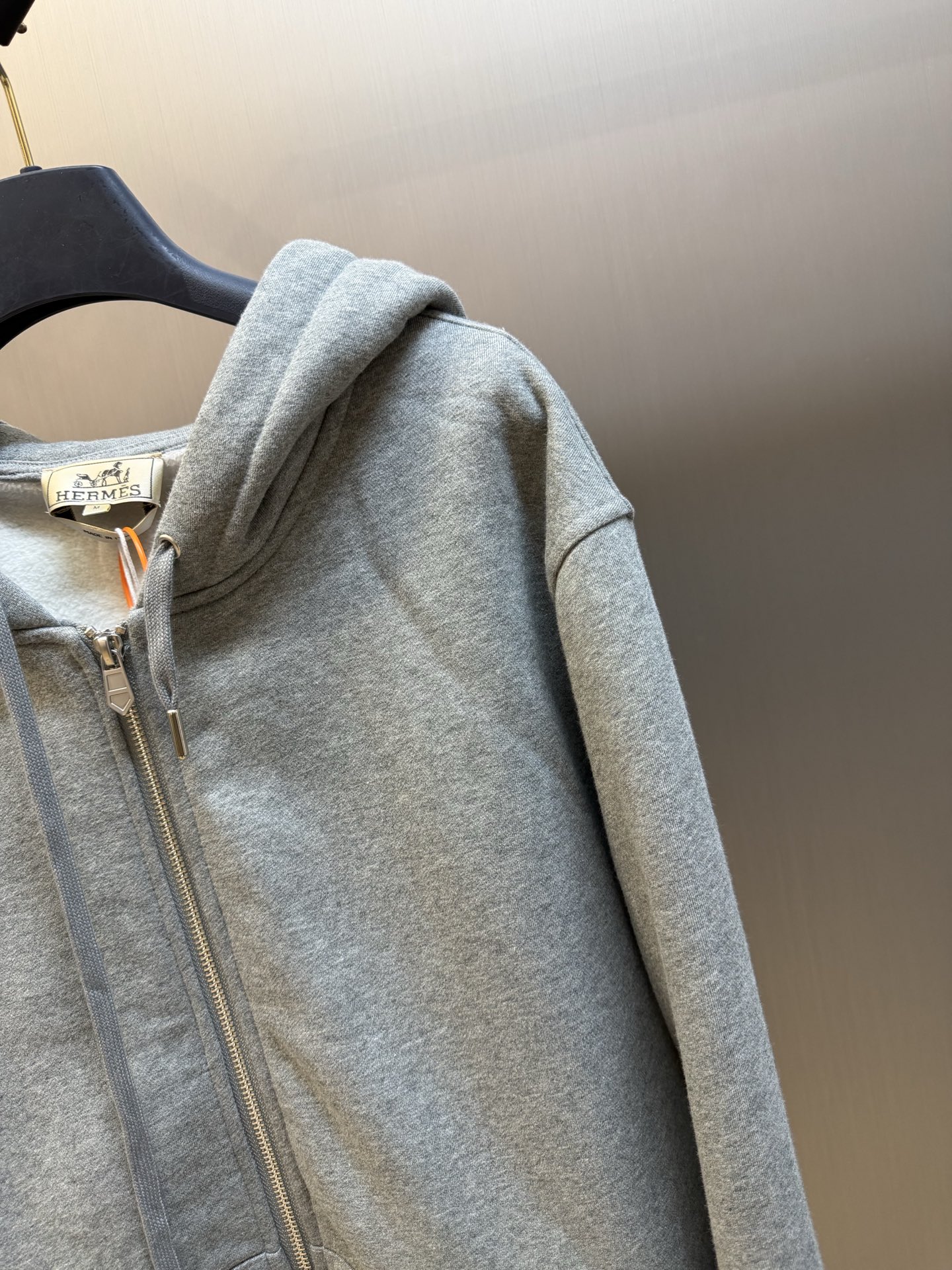 Hermès appliqué zippered jacket Customized wadding and heavy cotton velvet, a neat full-open zipper creates a smooth hooded configuration, the drawstring of the same color can be adjusted to the shape of the hood, and the kangaroo pocket hides practical ingenuity. The back is embellished with deconstructed equestrian totem patch printing, and the classic carriage and spur patterns are reconstructed through perspective art, laying out the brand's century-old equestrian heritage in the calm texture. - Image 3