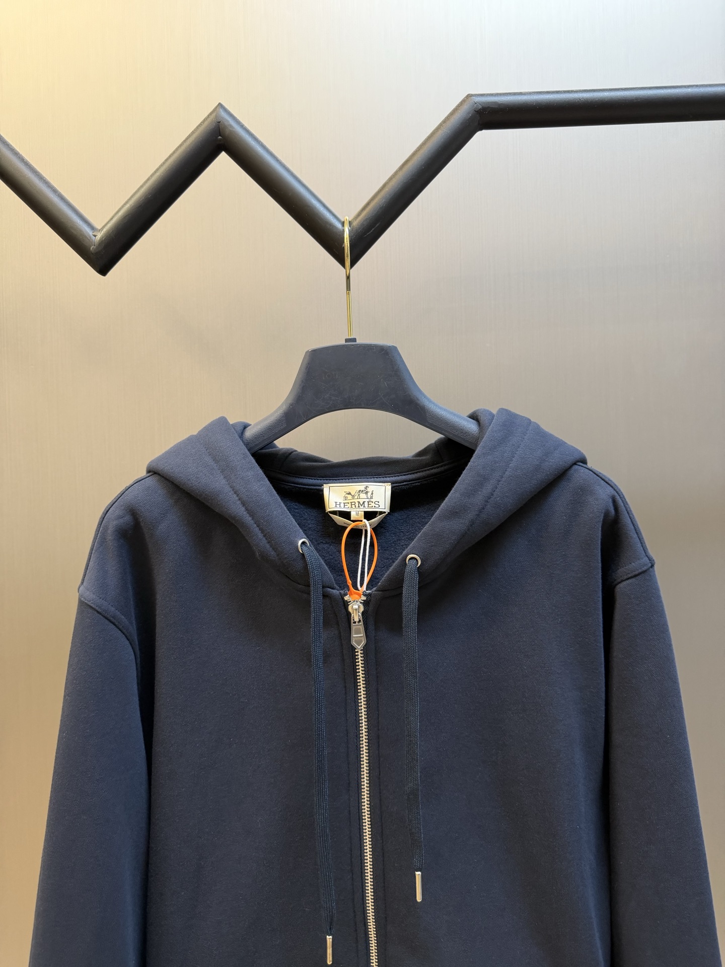 Hermès appliqué zippered jacket Customized wadding and heavy cotton velvet, a neat full-open zipper creates a smooth hooded configuration, the drawstring of the same color can be adjusted to the shape of the hood, and the kangaroo pocket hides practical ingenuity. The back is embellished with deconstructed equestrian totem patch printing, and the classic carriage and spur patterns are reconstructed through perspective art, laying out the brand's century-old equestrian heritage in the calm texture. - Image 2