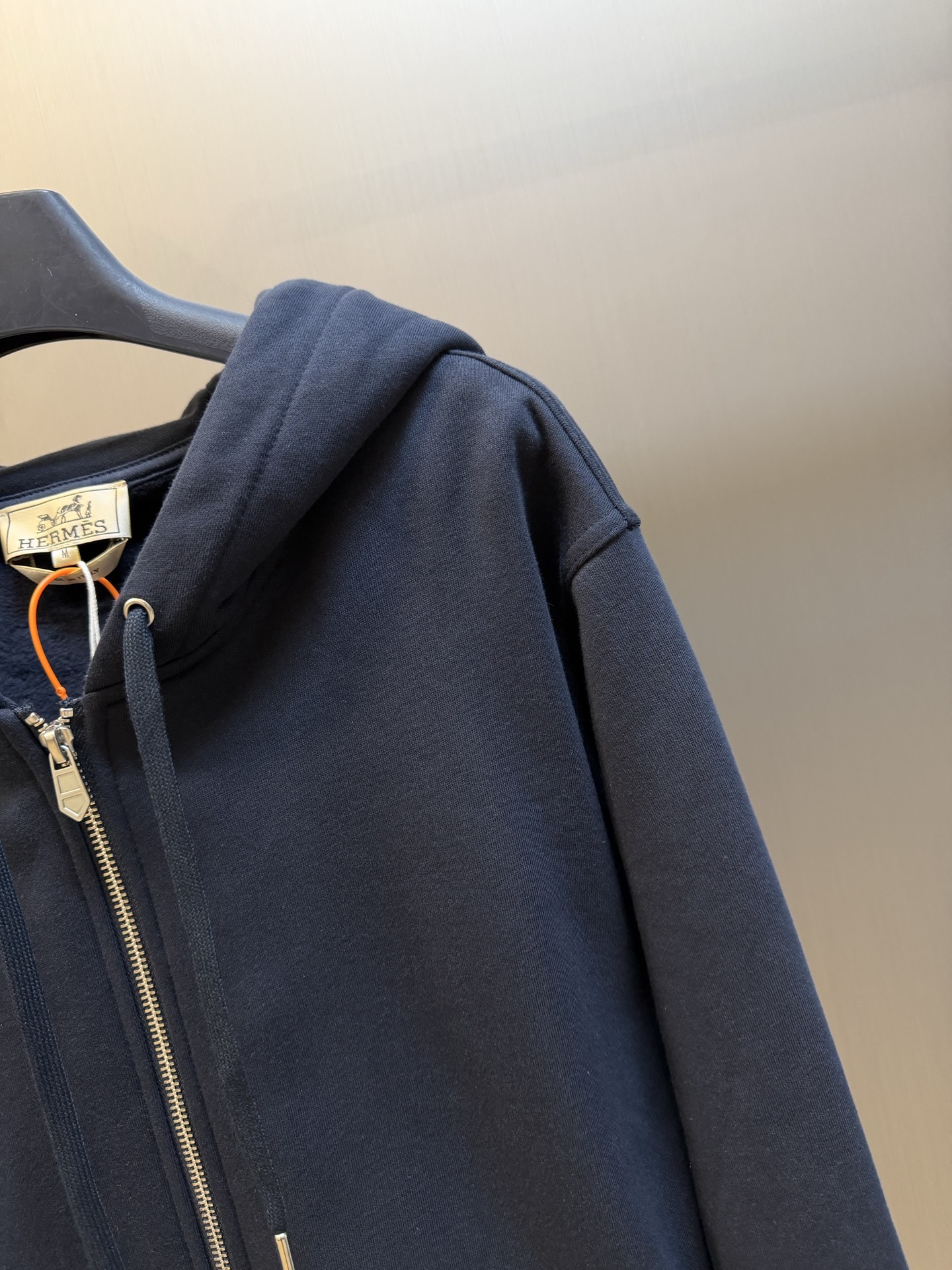 Hermès appliqué zippered jacket Customized wadding and heavy cotton velvet, a neat full-open zipper creates a smooth hooded configuration, the drawstring of the same color can be adjusted to the shape of the hood, and the kangaroo pocket hides practical ingenuity. The back is embellished with deconstructed equestrian totem patch printing, and the classic carriage and spur patterns are reconstructed through perspective art, laying out the brand's century-old equestrian heritage in the calm texture. - Image 3
