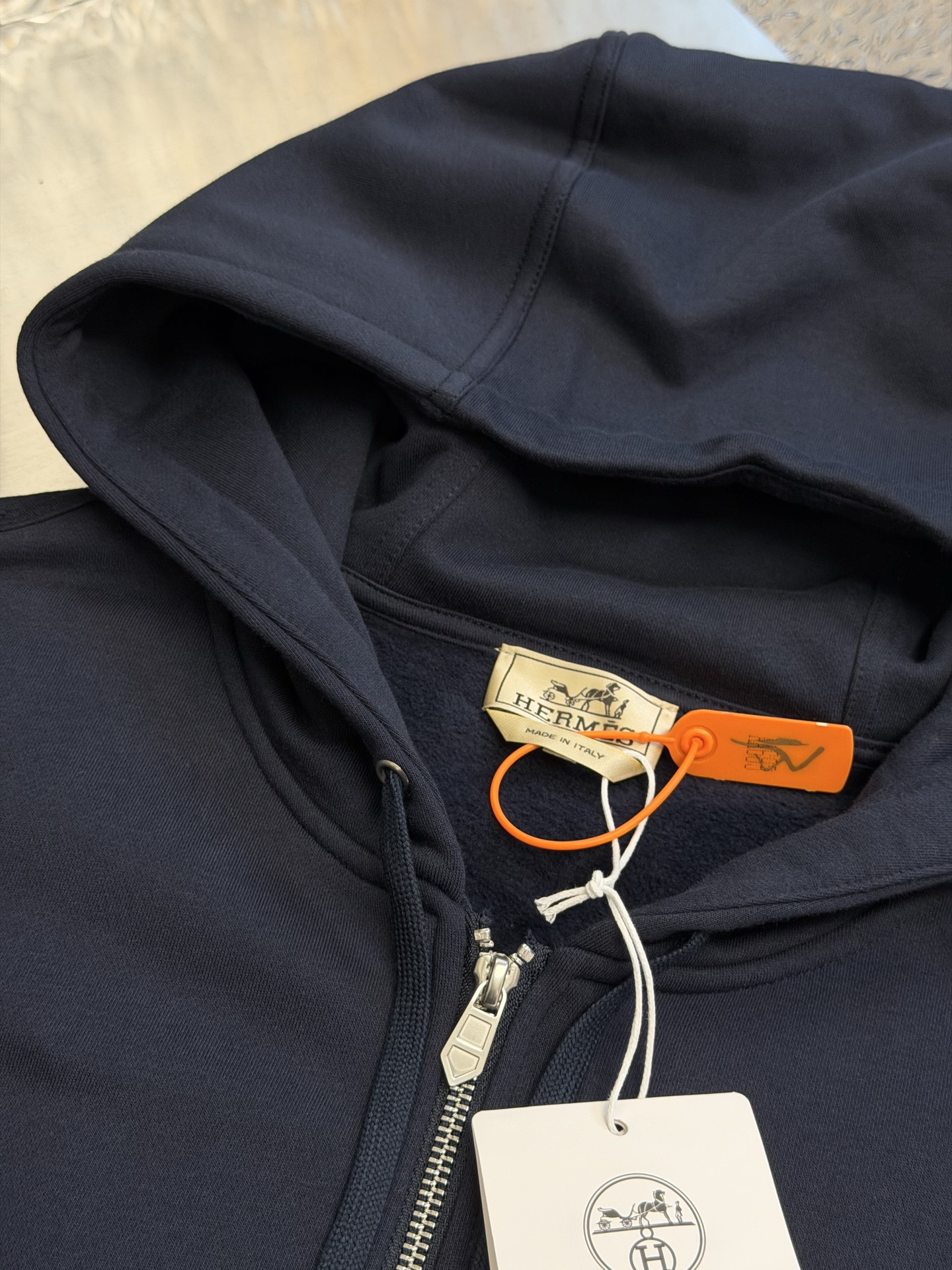 Hermès appliqué zippered jacket Customized wadding and heavy cotton velvet, a neat full-open zipper creates a smooth hooded configuration, the drawstring of the same color can be adjusted to the shape of the hood, and the kangaroo pocket hides practical ingenuity. The back is embellished with deconstructed equestrian totem patch printing, and the classic carriage and spur patterns are reconstructed through perspective art, laying out the brand's century-old equestrian heritage in the calm texture. - Image 5