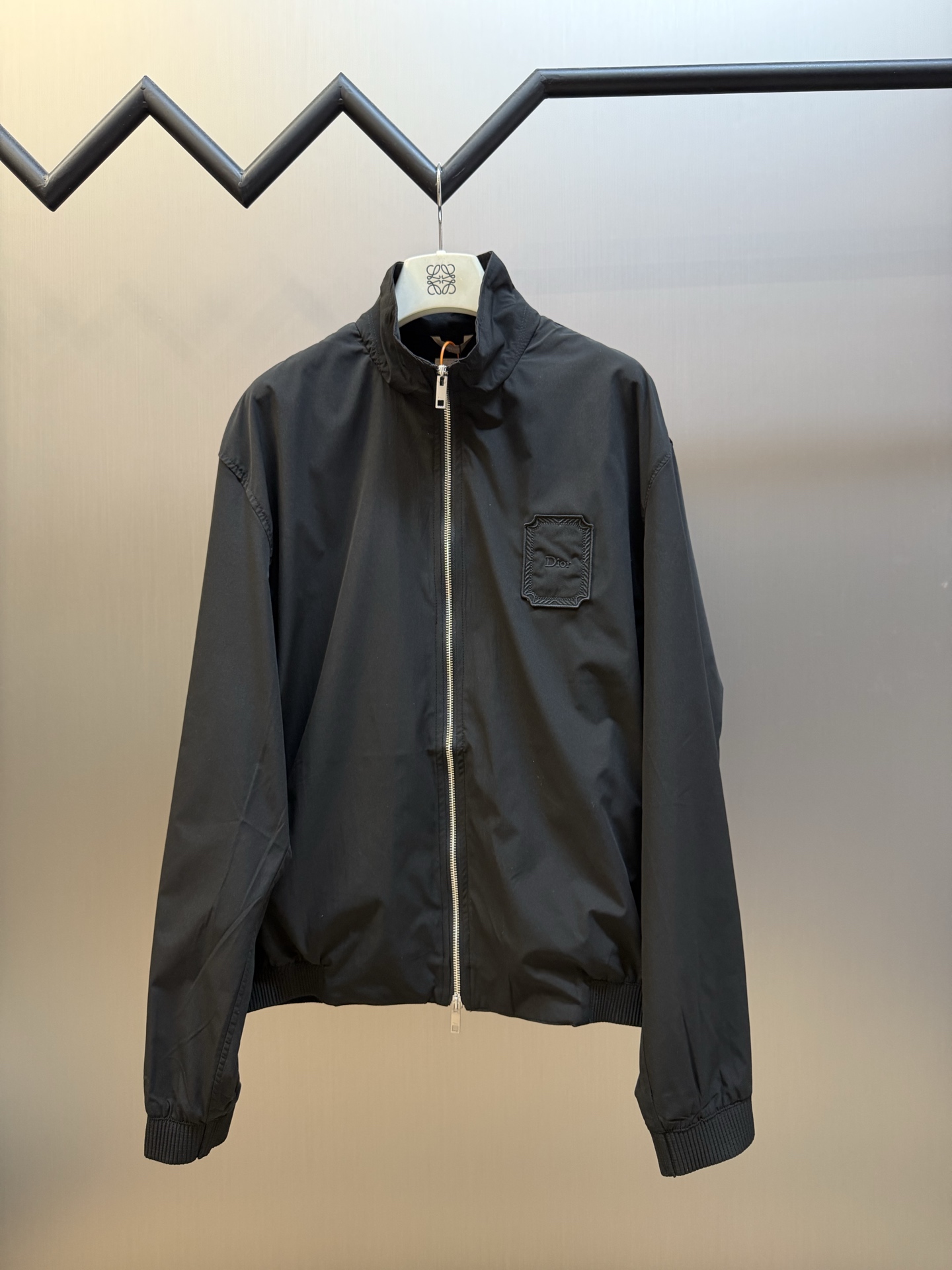 Dr Medaillon embroidered badge zipped jacket Customized Shen Yao Yun Xu worsted cotton, low saturation matte black tones to reduce the edge, neat stand-up collar outlines a simple silhouette, two-way metal zipper runs through the body, showing exquisite texture between opening and closing, embellished with Dr Médaillon logo patch on the chest, tracing back to the Rococo aesthetics of the brand salon in the 18th century, retro relief patterns are hidden in every square inch, engraved with the heritage of the Maison across time.