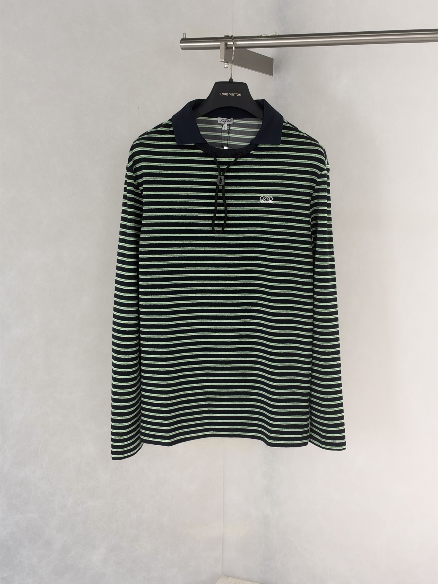 Loew*/Loewe SS26 terry cotton striped drawstring long-sleeved Polo shirt Custom-woven terry striped fabric, black base with green + white double thin horizontal stripes, color card repeatedly adjusted, stripe spacing and width are completely aligned with the original version, front and back textures are the same, navy blue woven splicing Polo collar, the fabric is crisp and not soft; the collar drawstring is matched with plastic buckles, the details are fully restored, the three-dimensional embroidery logo on the chest, the stitching is dense and full, and the positioning is accurate Size:S/M/L/XL