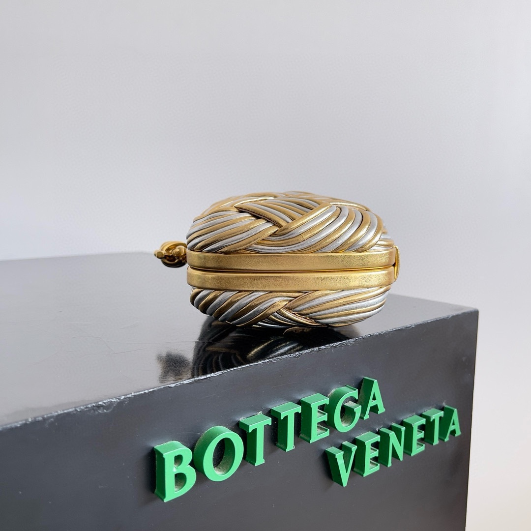 B.V. π Knot Evening Clutch This clutch is crafted from interwoven strips of gold and silver two-tone leather, paired with the iconic Knot metal twist detail and structured frame design. - Image 3