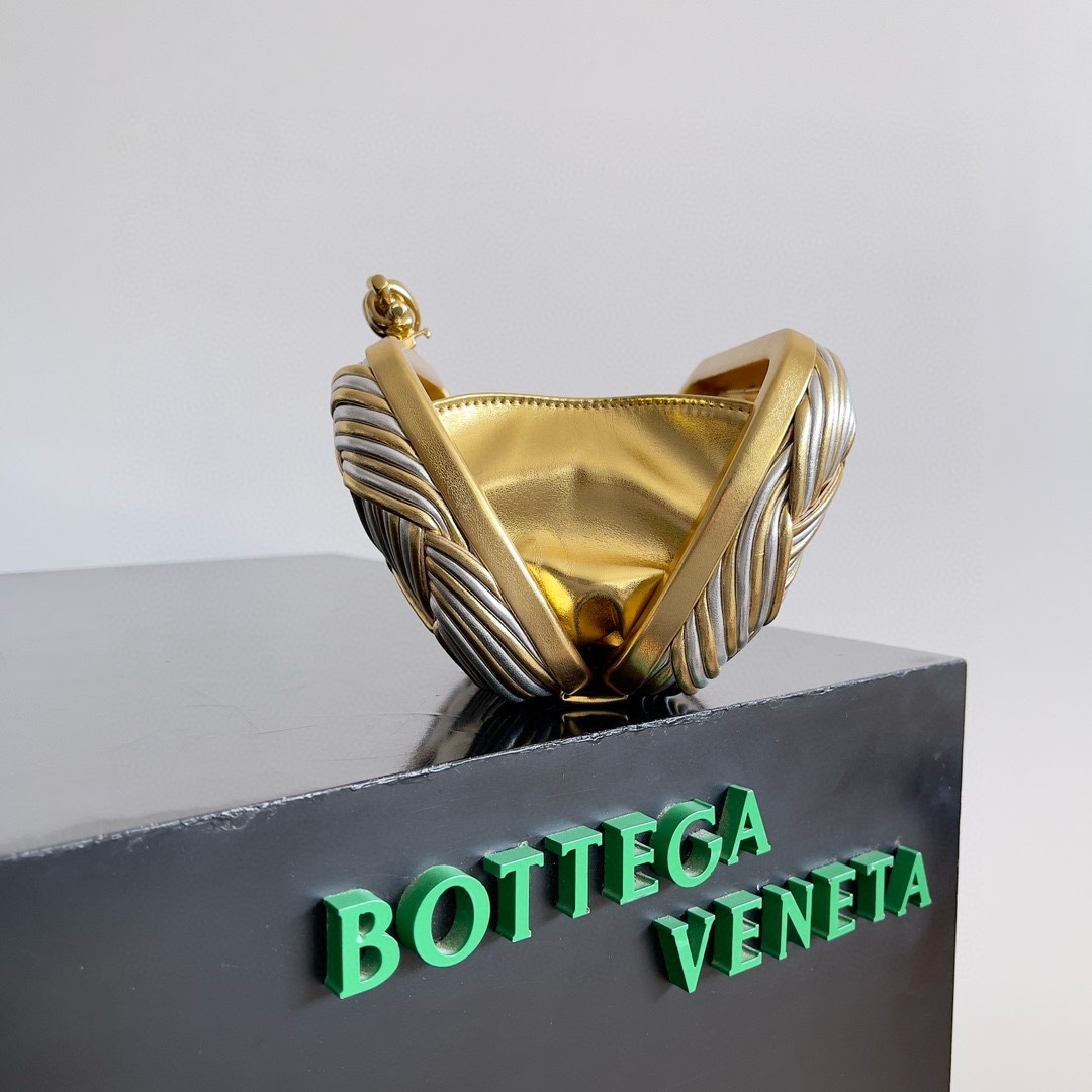 B.V. π Knot Evening Clutch This clutch is crafted from interwoven strips of gold and silver two-tone leather, paired with the iconic Knot metal twist detail and structured frame design. - Image 5