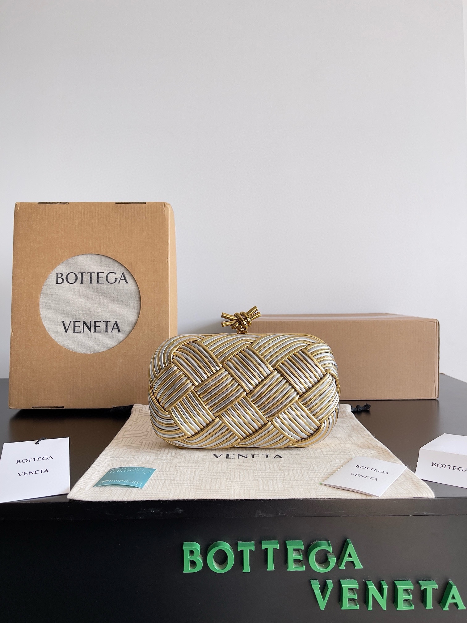 B.V. π Knot Evening Clutch This clutch is crafted from interwoven strips of gold and silver two-tone leather, paired with the iconic Knot metal twist detail and structured frame design. - Image 10