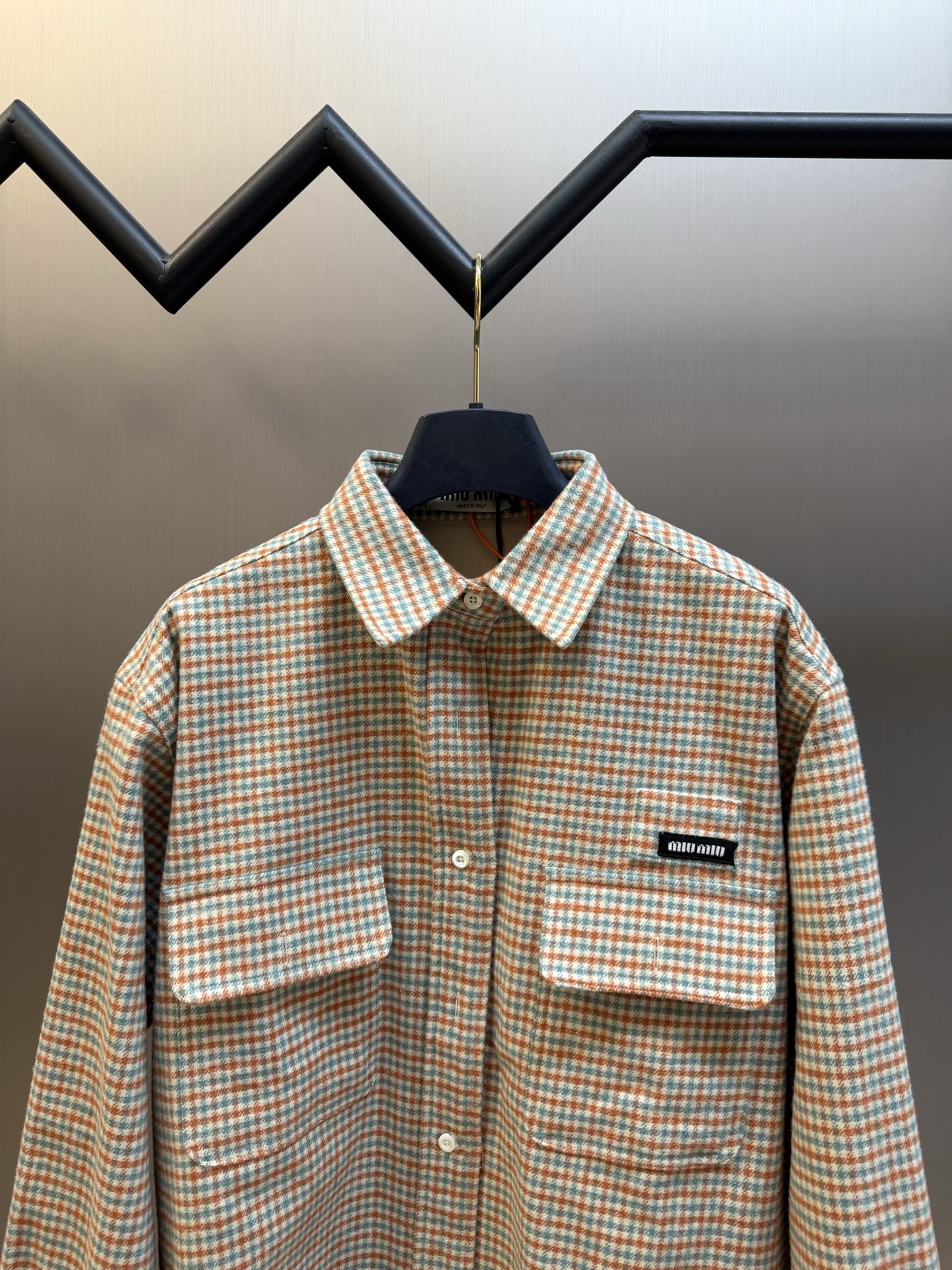 Miu logo checked shirt jacket Customized amber wool blend, woven with orange ocher and mint green warp and weft, fine yarn-dyed small plaid spreads over the body, matte fabric surface exuding Italian college retro charm, double patch pockets on the chest draping, integrating style layering and storage practicality, black embellished on the patch pockets The woven label logo is hidden in the staggered plaid texture, engraving the brand's family genes in every square inch - Image 2