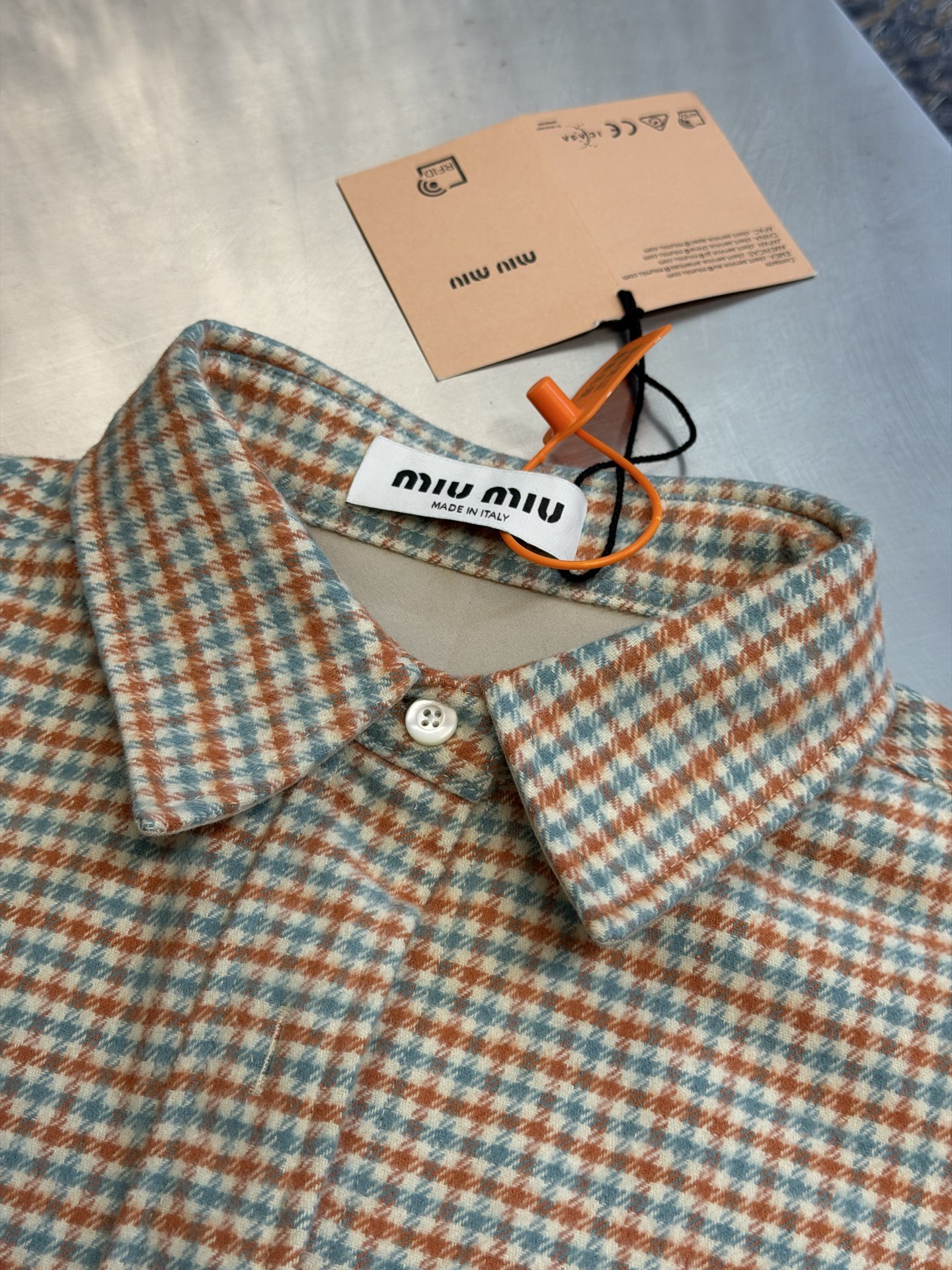 Miu logo checked shirt jacket Customized amber wool blend, woven with orange ocher and mint green warp and weft, fine yarn-dyed small plaid spreads over the body, matte fabric surface exuding Italian college retro charm, double patch pockets on the chest draping, integrating style layering and storage practicality, black embellished on the patch pockets The woven label logo is hidden in the staggered plaid texture, engraving the brand's family genes in every square inch - Image 5