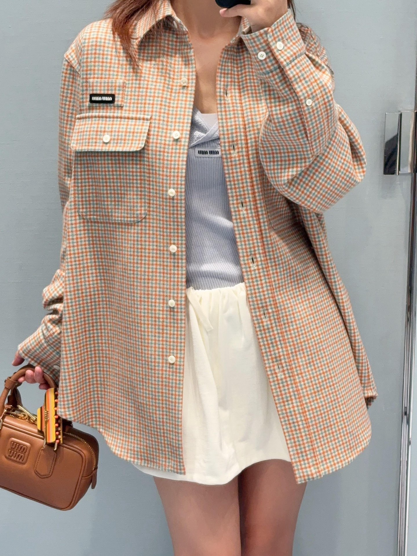 Miu logo checked shirt jacket Customized amber wool blend, woven with orange ocher and mint green warp and weft, fine yarn-dyed small plaid spreads over the body, matte fabric surface exuding Italian college retro charm, double patch pockets on the chest draping, integrating style layering and storage practicality, black embellished on the patch pockets The woven label logo is hidden in the staggered plaid texture, engraving the brand's family genes in every square inch - Image 13