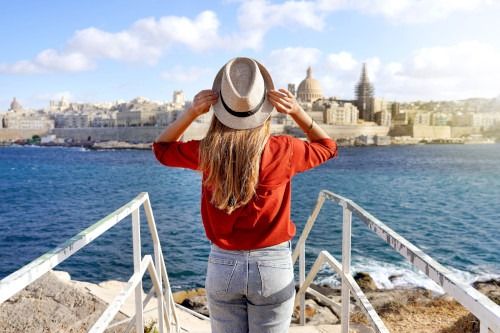 Una turista de espaldas a la cámara contemplando el skyline y la costa de Malta