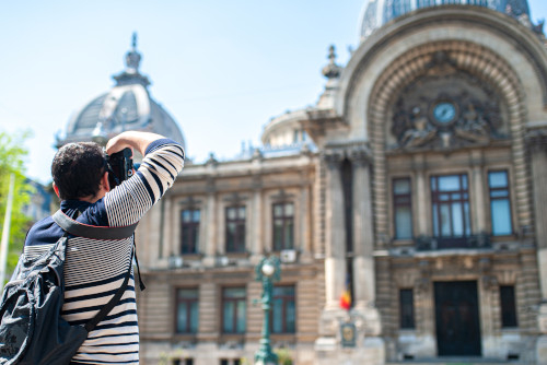 Una turista fotografiando el antiguo palacio bursátil de Bucarest