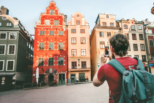 Un turista fotografiando las casas de colores de la plaza más antigua de Estocolmo