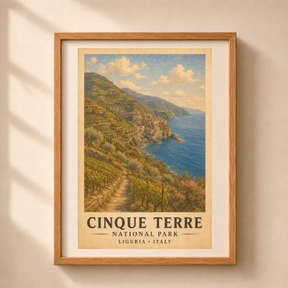 Vertical framed art print of Cinque Terre National Park featuring terraced vineyards, coastal village, and blue sea in a warm oak frame hanging on a beige wall with light shadows.