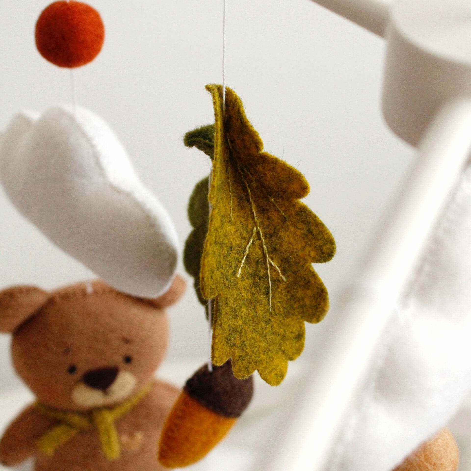Green leaves in different shades form the forest felt crib mobile