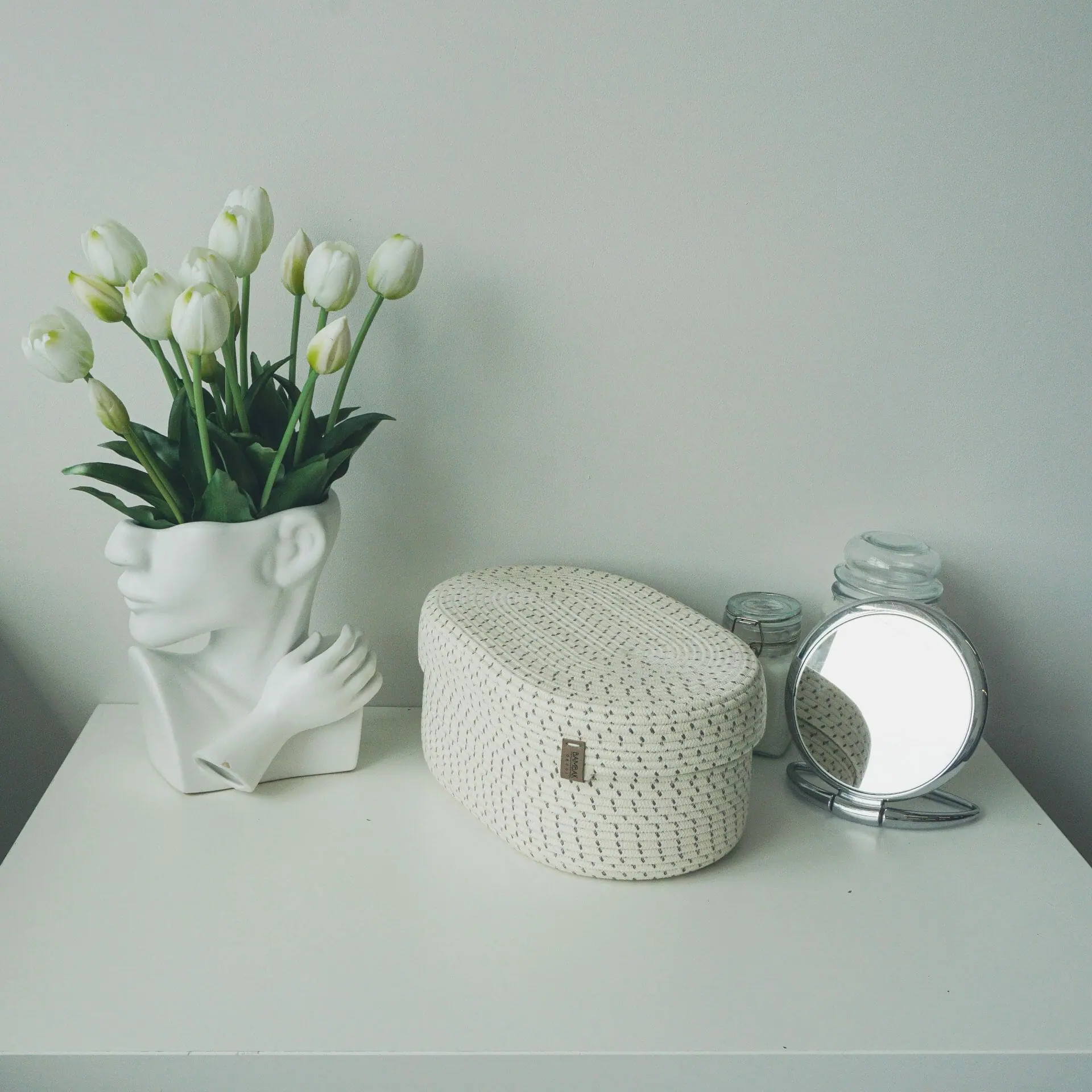 oval white rope basket with lid on table