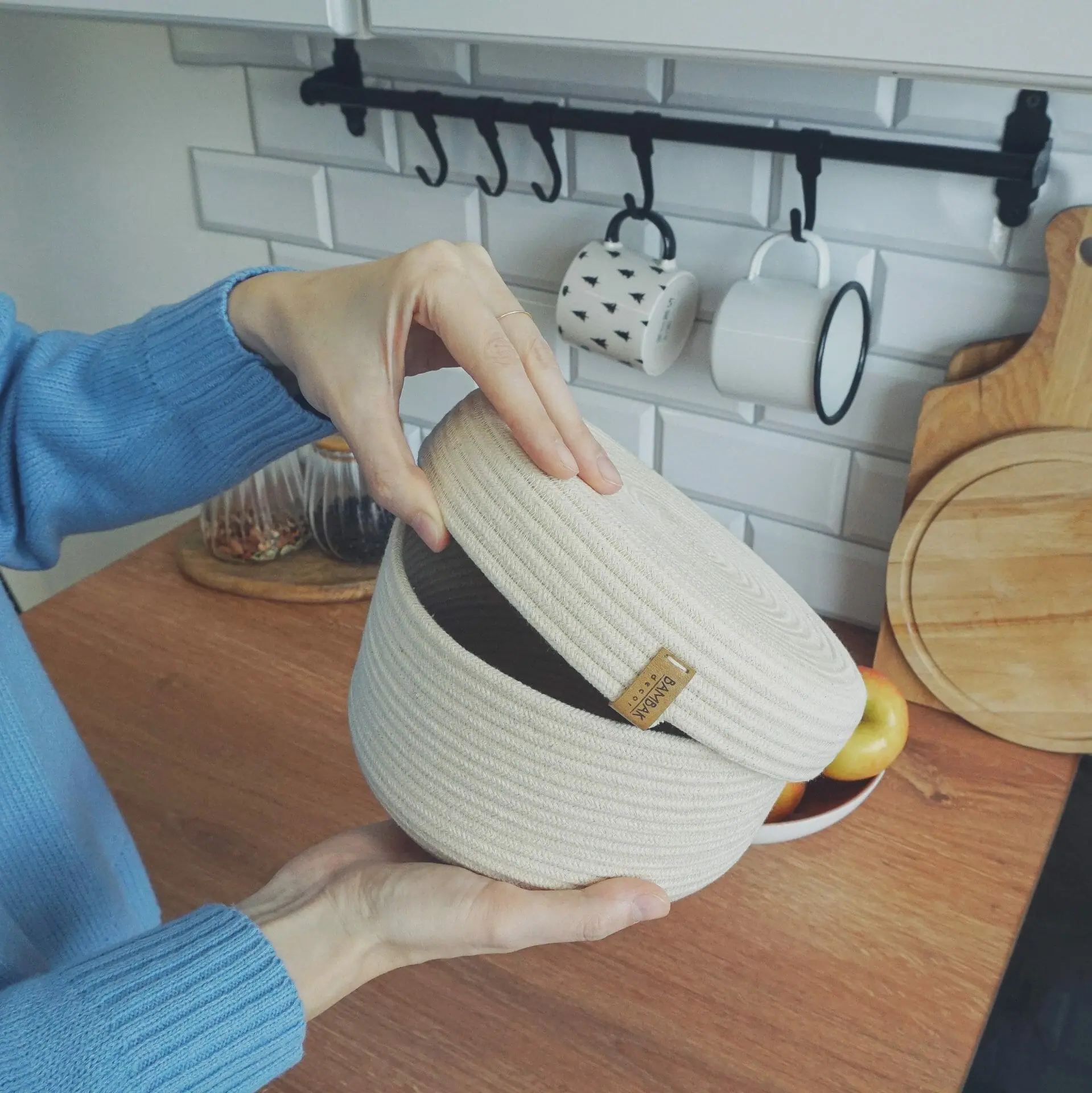white rope basket with lid in hands