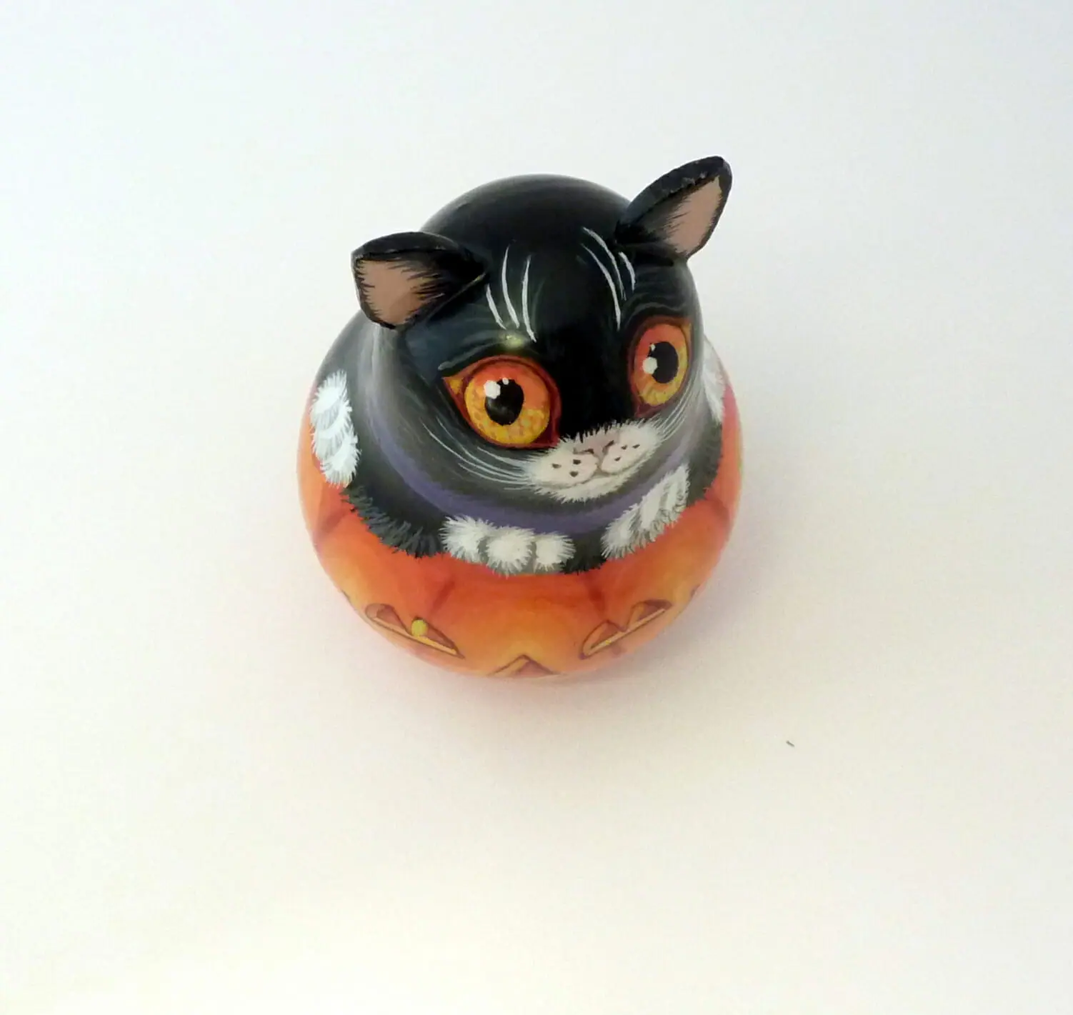 a small decorative pumpkin and a black cat . an unusual bell for halloween . wooden tinkling roly poly doll hand painted 3.jpg