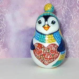 A cute penguin with a heart of roses . Roly poly toy