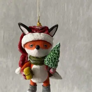 Christmas Tree toy fox in a santaclaus hat with a Christmas tree and a gift in his hand