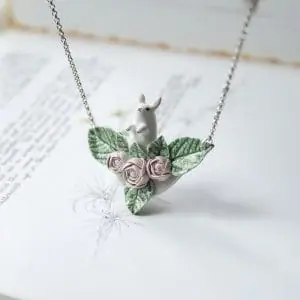 handmade ceramic necklace with bunny sitting in the leaves and roses