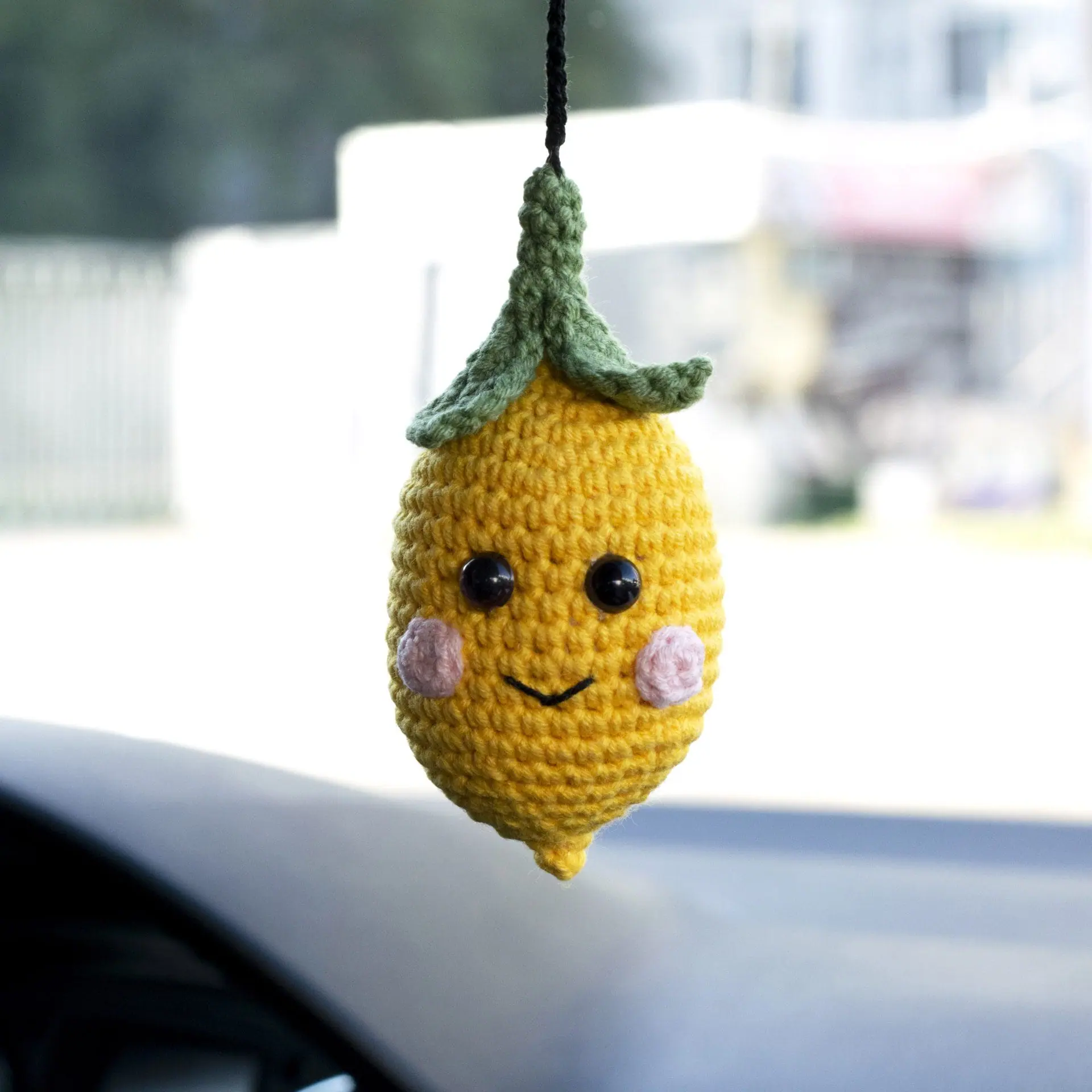 Crocheted lemon charm car accessory on the rearview mirror
