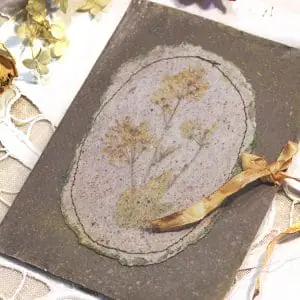 The brown handmade postcard with pressed wildflowers