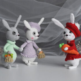 3 easter bunnies. 2 rabbits with baskets, a rabbit in red clothes with a large carrot.