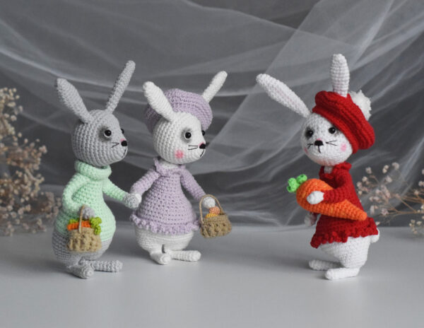 3 easter bunnies. 2 rabbits with baskets, a rabbit in red clothes with a large carrot.