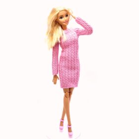 Barbie doll in pink knitted dress with pattern on the sleeves and front