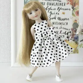 A Ruby Red Fashion Friends doll in an elegant white dress with black polka dots