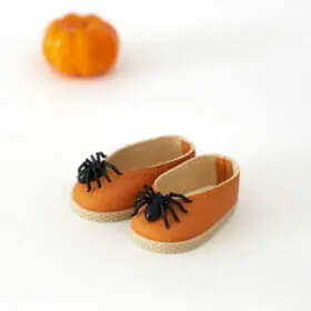 Little orange doll shoes with spider