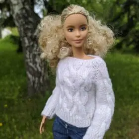 Side view of Barbie doll wearing white knit sweater