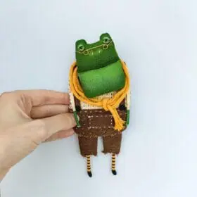 one-of-a-kind-textile-art-doll-frog-boy-in-brown-pants-in-hand