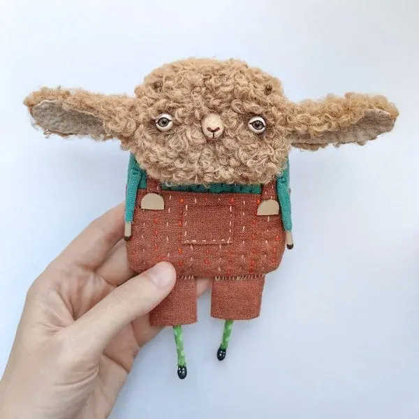 one-of-kind-textile-art-doll-sheep-in-terracotta-pants-in-hand
