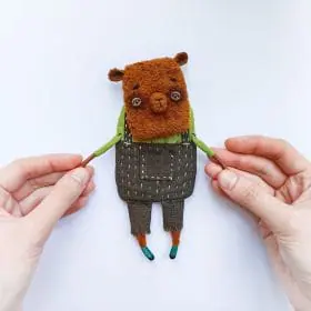 textile art doll capybara in pants in hands