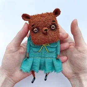 textile art doll bear in dress in hands