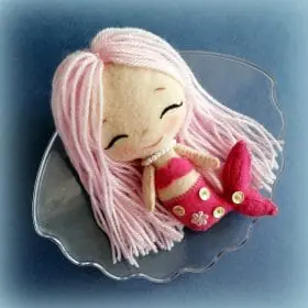 Felt toy Rosie the little mermaid with long yarn hair and a tail, decorated with sequins