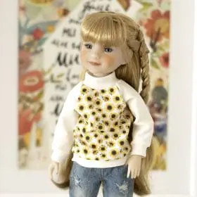 A 14-inch Ruby Red doll in a sweatshirt with a sunflower print.